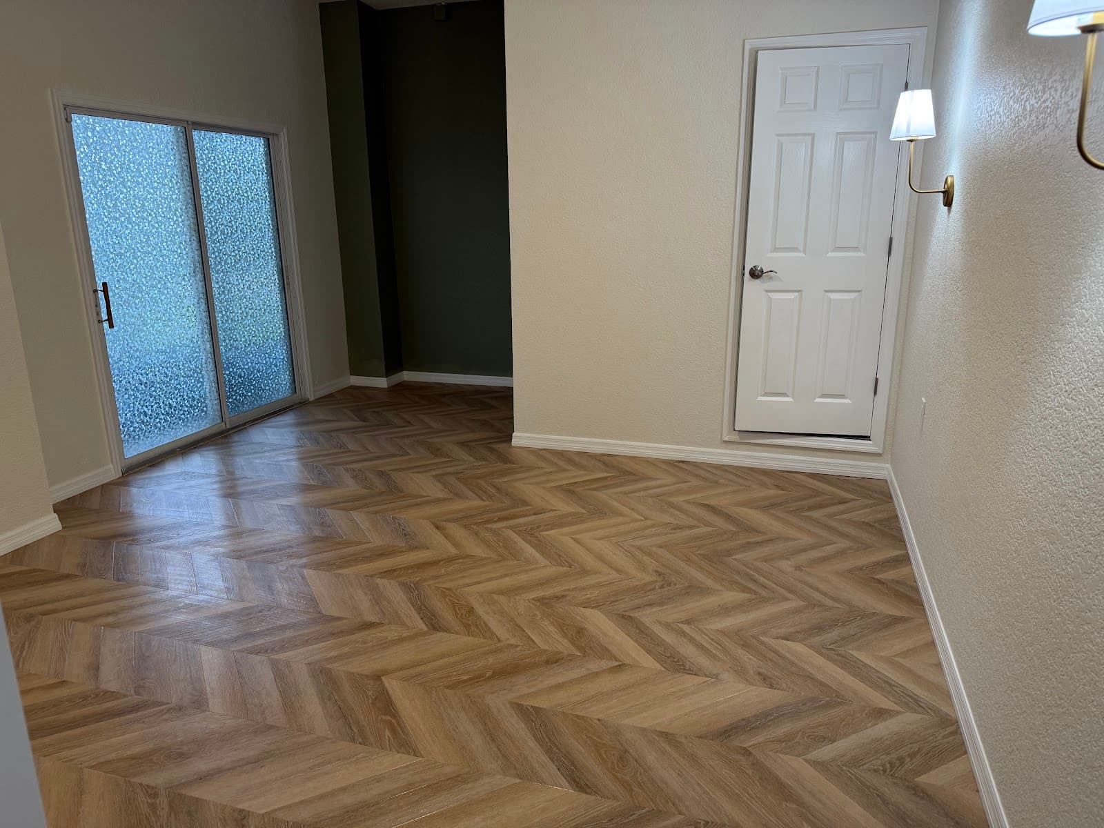 Herringbone wood-look flooring installation by Devon's HomePro in a Tampa Bay home remodel with white trim and a green accent wall